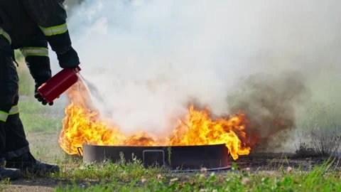 Firefighter extinguishing fire using extinguisher outdoors. Video stock 283279184