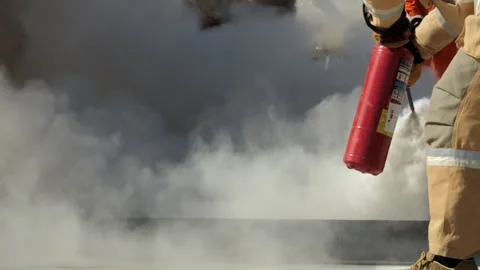 Firefighter extinguishing flames with CO2 fire extinguisher Stock Footage 321408452