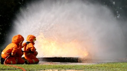 Firefighter fighting with fire flame protection property. Fireman wear hard hat, 動画素材 124563424