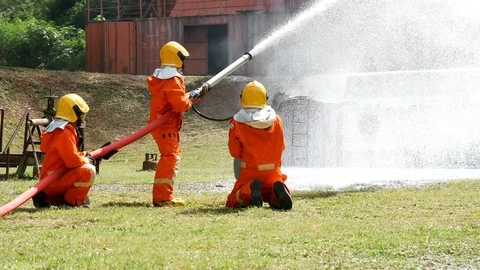Firefighter fighting with fire flame protection property. Fireman wear hard hat, Видео 124568492