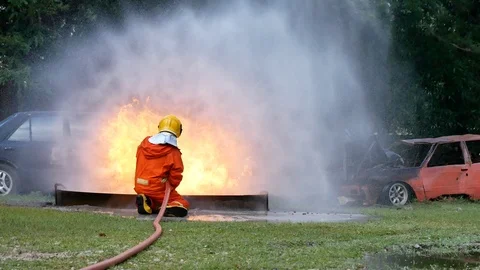 Firefighter fighting with fire flame protection property. Fireman wear hard hat, Video stock 124570034