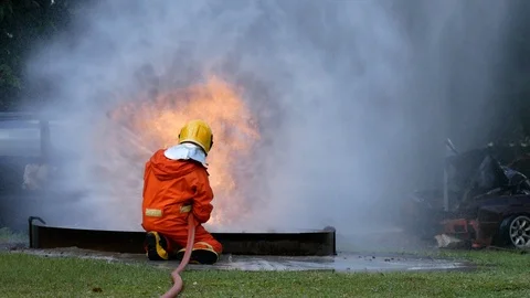 Firefighter fighting with fire flame protection property. Fireman wear hard hat, Stock Footage 124570679