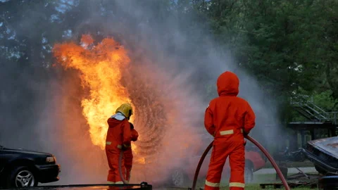 Firefighter fighting with flame using fire hose chemical water foam spray engine Видео 148544205