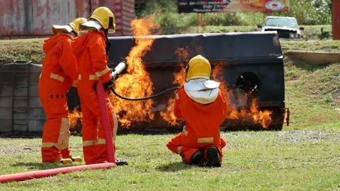 Firefighter fighting with flame using fire hose chemical water foam spray engine Stock Footage 148545075