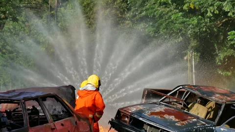 Firefighter fighting with flame using fire hose chemical water foam spray engine Stock-Footage 154354178