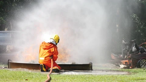 Firefighter fighting with flame using fire hose chemical water foam spray engine Vidéo 154355257