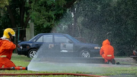 Firefighter fighting with flame using fire hose chemical water foam spray Stock-Footage 337748846
