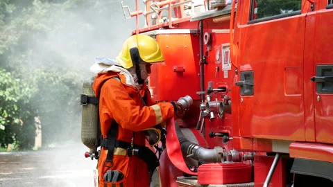 Firefighter fighting with flame using fire hose chemical water foam Stock Footage 337750957
