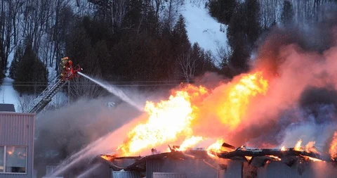 Firefighter fighting a fully involved fire factory from the ladder Stock Footage 104770751
