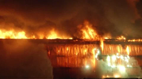 Firefighter fighting intense fire in a large warehouse Stock Footage 42855030