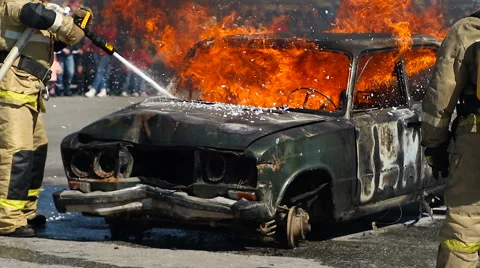 Firefighter Fire Brigade dispense foam on burning car during drill Stock Footage 62851228