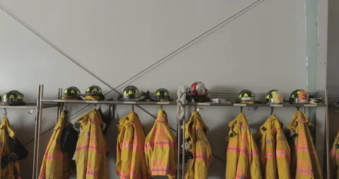 Firefighter gear hanging in fire station Stock Footage