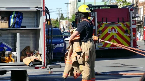 Firefighter getting his coat off during hot day Stock Footage 139664479