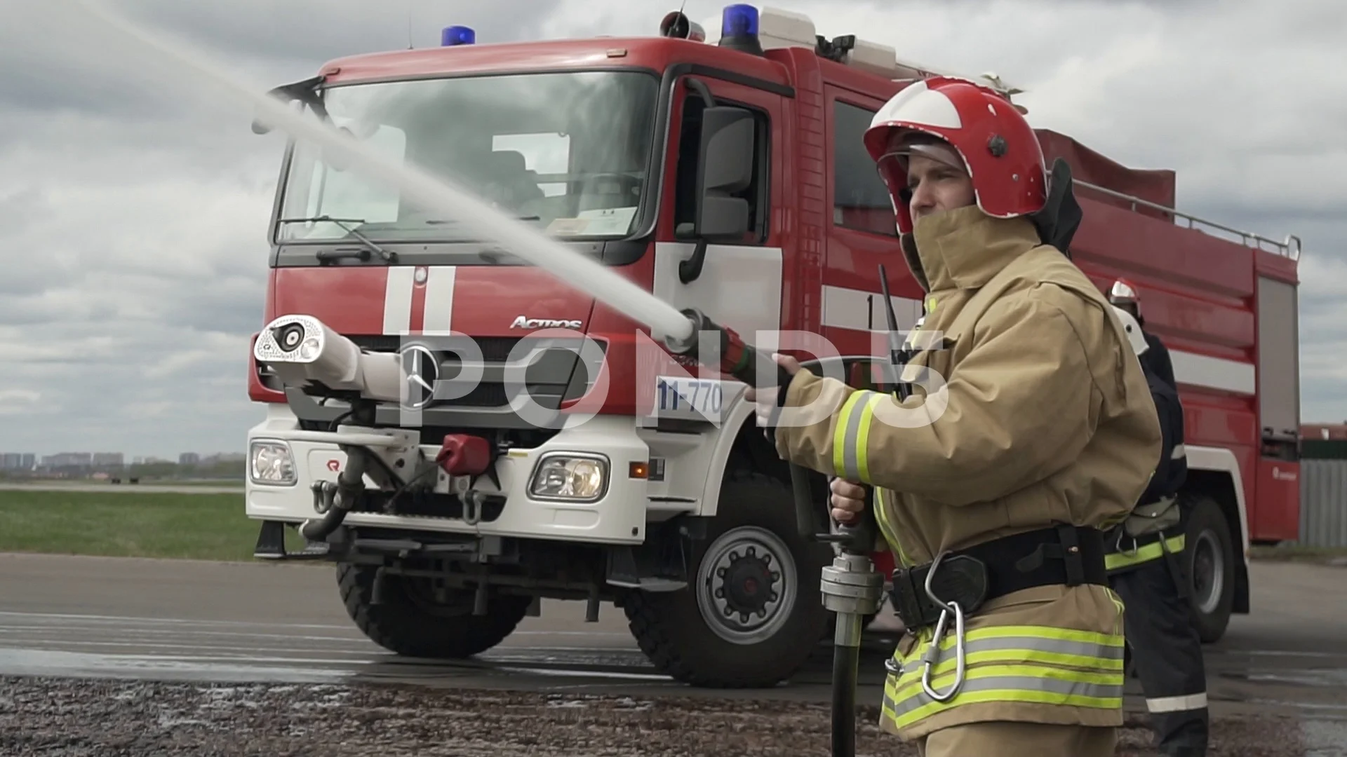 Firefighters Holding Hose Into Building On Fire High-Res Stock