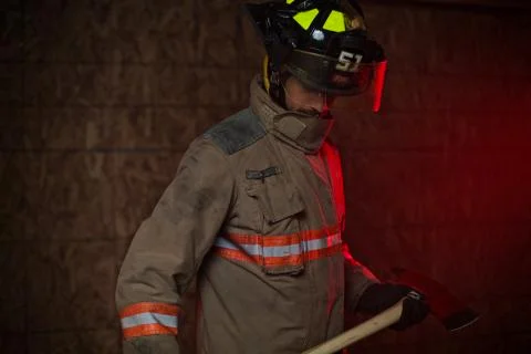 Firefighter holds axe - Epic hero Stock Photos