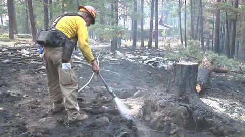 Firefighter with hose cooling hot spots Stock Footage 40753722