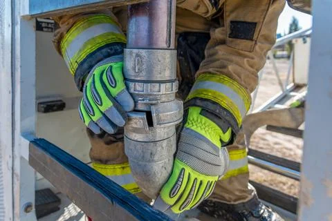 Firefighter joining hose lines to put out fires. Stock Photos