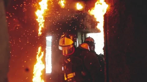 A firefighter knocks out the burning door Stock Footage 76850465