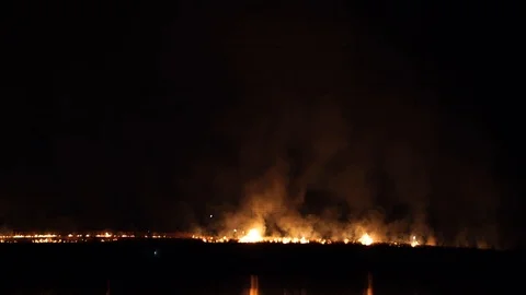 Firefighter with a lantern makes his way to the center of the fire. Night Fire Stock-Footage 88476333