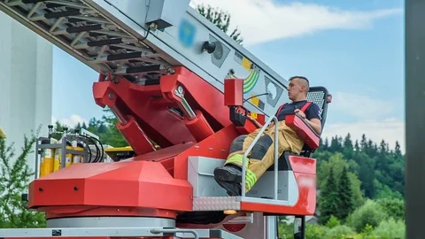 Firefighter is navigating a device so that a ladder is moving up Video stock 106563312