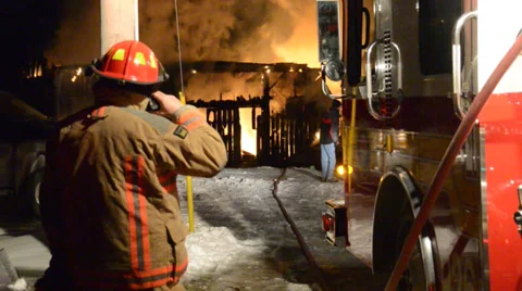 Firefighter Operating pump with fire and flames in background Stock Footage 36630683