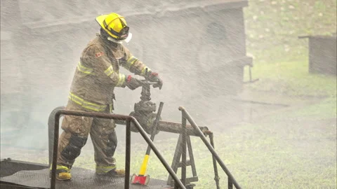A firefighter in protective gear manually turns off a water valve Stock-Footage 326218824