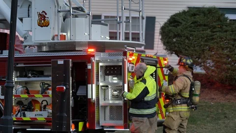 Firefighter pulling long staff from the back of firetruck Stock Footage 125530703
