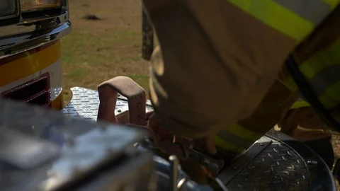 Firefighter pulls a fire hose out of a firetruck to get ready to fight a Stock Footage