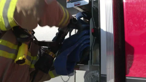 A firefighter pulls a hose from a fire truck to fight a fire Stock-Footage 232644956