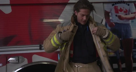 Firefighter Putting on Jacket In Front of Fire Truck Stock-Footage 101666163