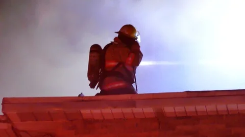 Firefighter putting mask on his face during structure fire Stock Footage 104299016