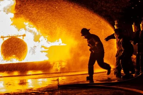 Firefighter running towards fire Stock Photos