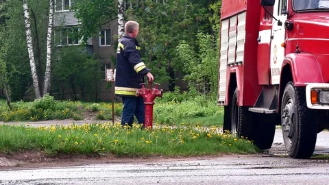 Firefighter screws a fire hydrant into a sewer. Stock Footage 109388625
