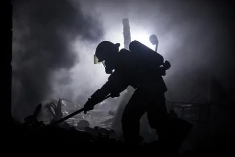 Firefighter in shadow using ceiling hook Stock Photos
