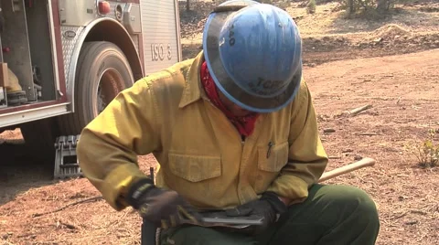 Firefighter sharpening polaski Stock Footage 40750822