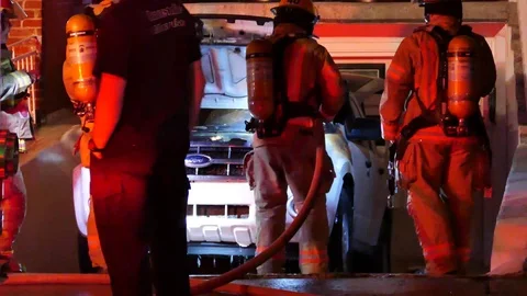 Firefighter splashing car fire Stock Footage 99875143