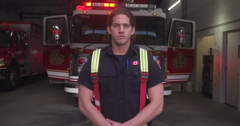 Firefighter Standing In Front of Fire Truck With Flashing Lights Stock Footage 101665749