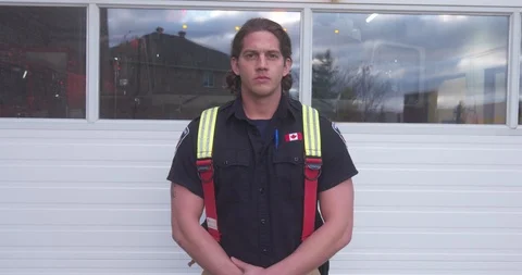 Firefighter Standing In Front of Garage Opening With Fire Truck in Background Stock Footage 101666331