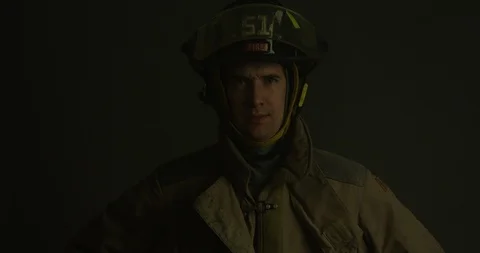 Firefighter stands looking towards camera as red light blink from the side Vídeos de archivo 103656671