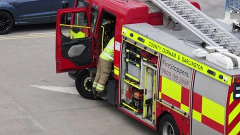 Firefighter stows gear in fire engine, removes helmet and jacket after shift at Stock Footage 340123199