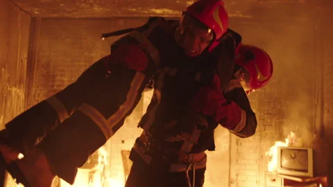 Firefighter taking another firefighter out of a burning house Stock Footage 283143519