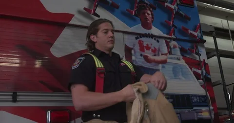 Firefighter Taking Off Jacket In Front of Fire Truck Stock-Footage 101666321