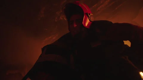 A Firefighter taking unconscious firefighter out of a burning house Stock Footage 283143366