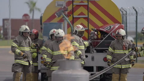 Firefighter team extinguishing a dangerous propane tank gas fire during training Stock Footage 345101930