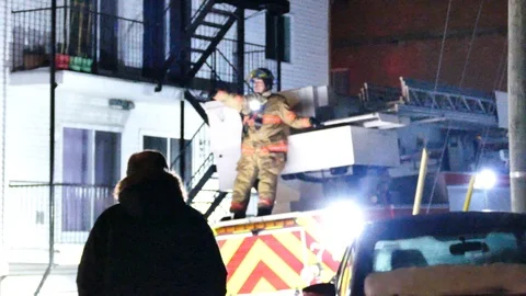 Firefighter on top of firetruck while backing off in a tough spot Stock Footage 125455425