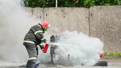 Firefighter training exercise. Man using fire extinguisher to extinguish fire Stock Footage 303806653