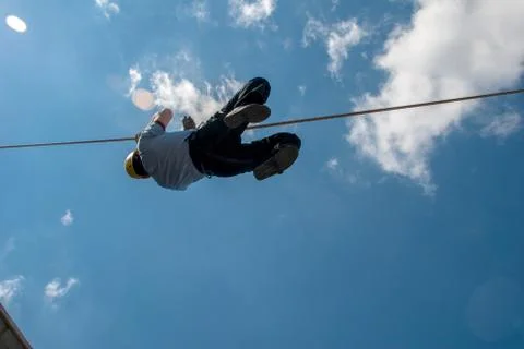 Firefighter training on wire, blue sky and clouds Stock-Fotos