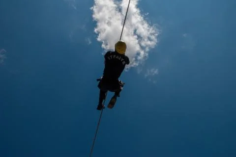 Firefighter training on wire, blue sky and clouds Stock Photos