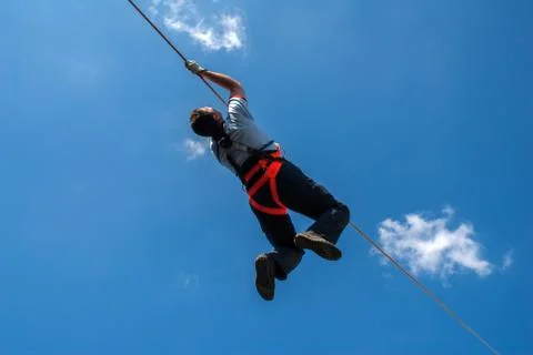 Firefighter training on wire, blue sky and clouds Stock Photos
