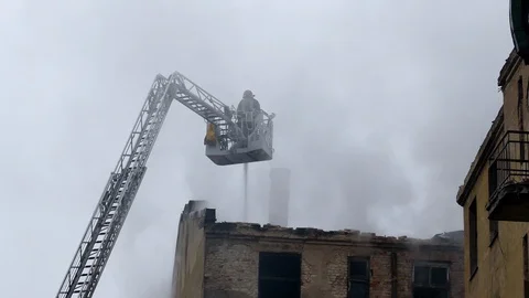 Firefighter on turntable ladder fighting fire 動画素材 99401418
